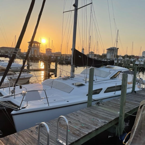 a white boat on a dock during a sunset